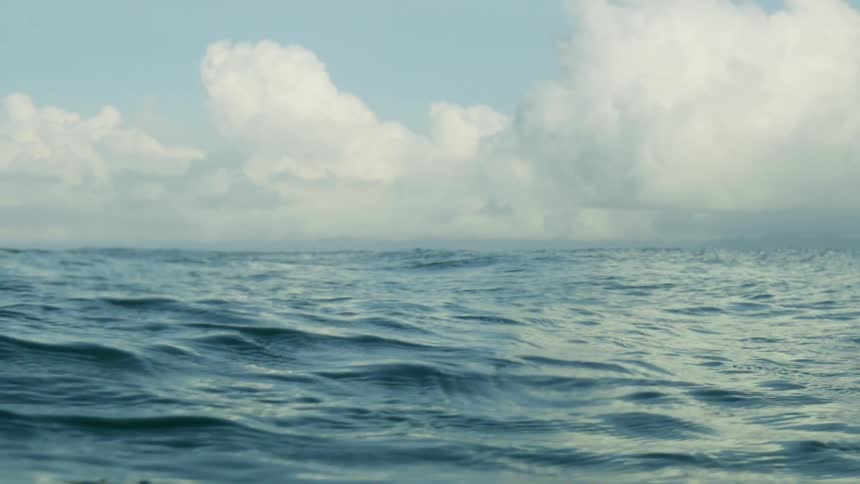 Landscape of body of ocean water and white clouds