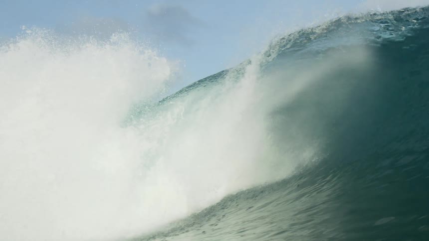 A surfer rides out a wave without standing up