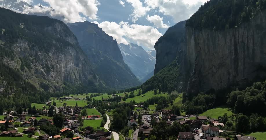 Aerial view of town in valley between high and steep mountains
