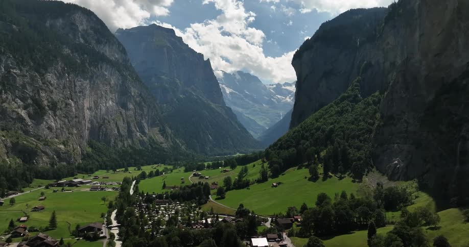 Large mountains with steep cliffs hang over a small town