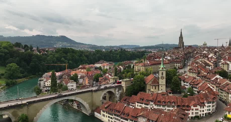 Aerial view of the tiled red roofs and towers on an european town near a bridge over a river