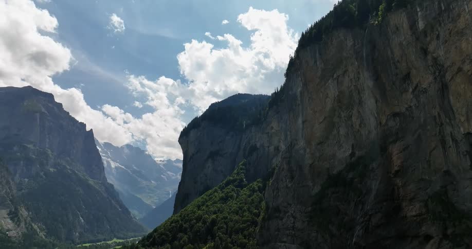 A small town is in a valley with towering steep mountains