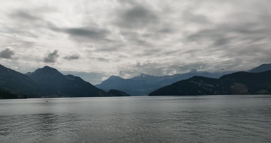 Waves crash onto the shore below a mountain range