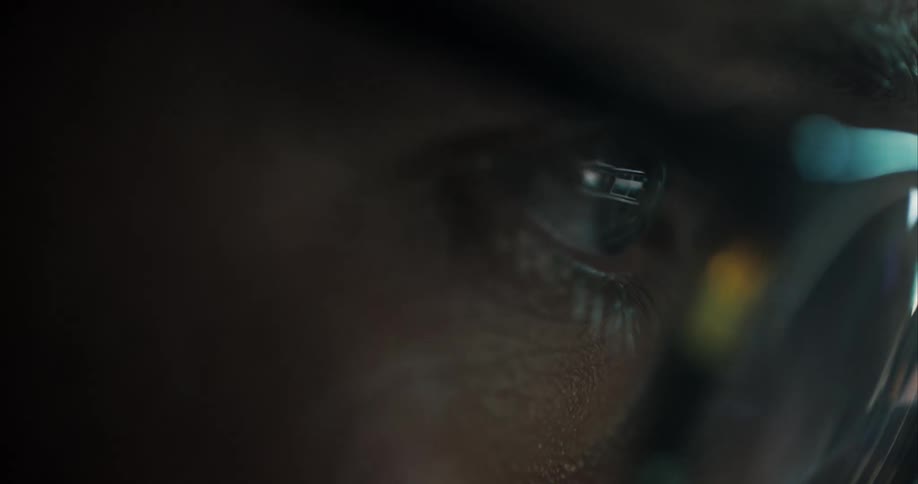 Extreme close up of the eyes of a man wearing glasses looking at shifting lights