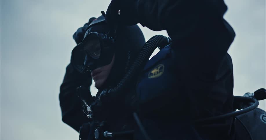 A diver puts on his goggles