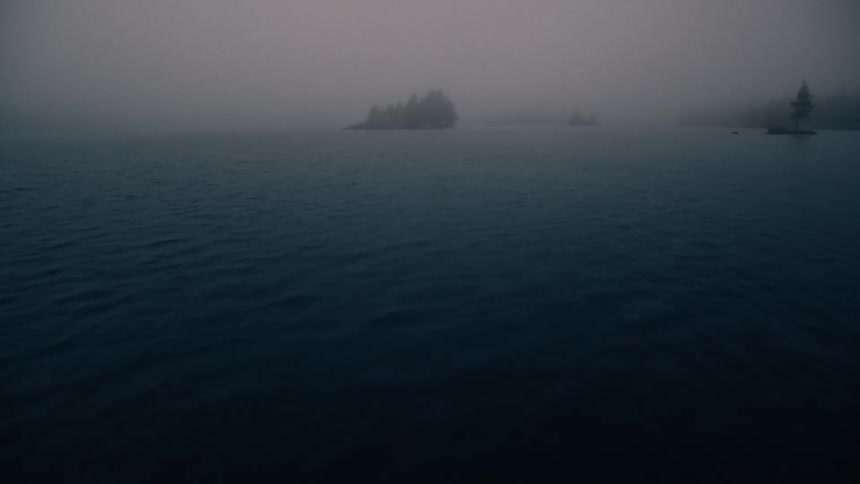Small islands with trees on them dot the water along a coast