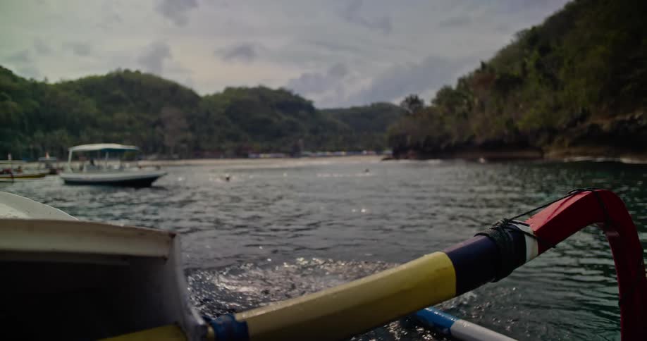 A man dives off of a boat into a lake during the day