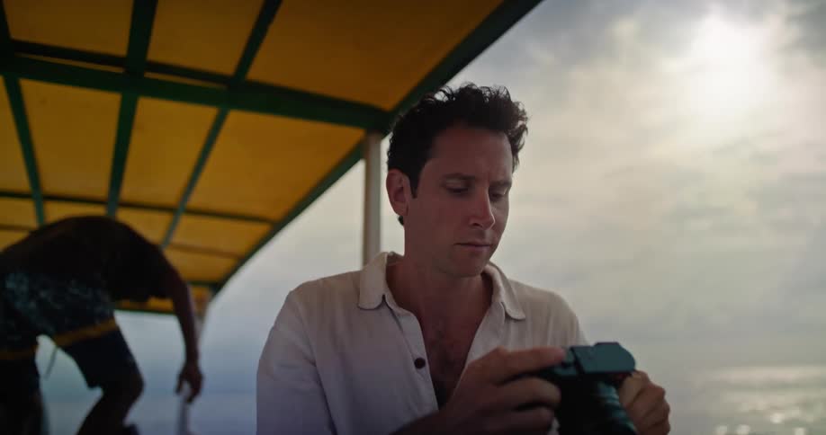 A man is sitting on a boat taking pictures