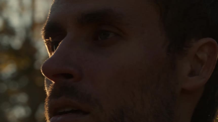 A man stares straight forward as he stands outside