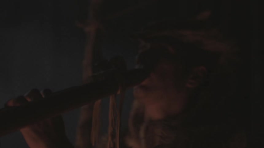 A tribal man plays an instrument
