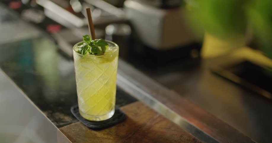 A person sets a cocktail down on a counter