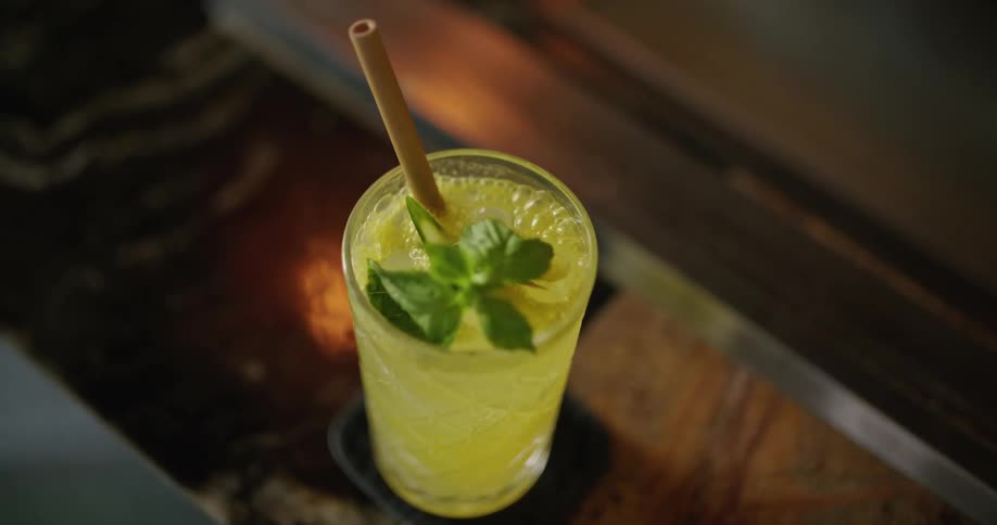 A person puts a cocktail on a coaster