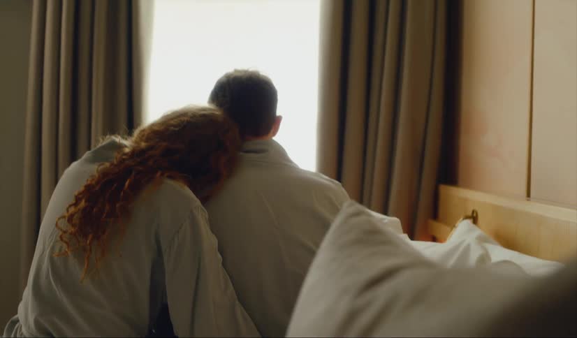A couple sit together in bed