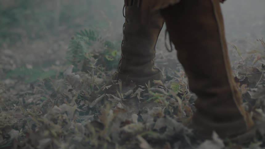 A person is walking over some leaves