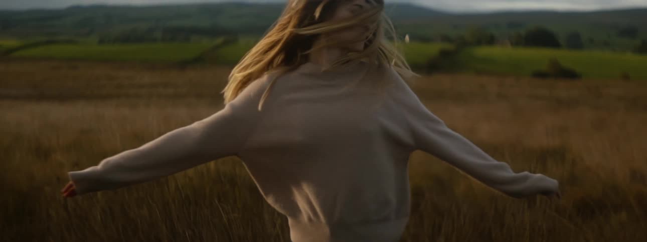 A woman is dancing in the grass