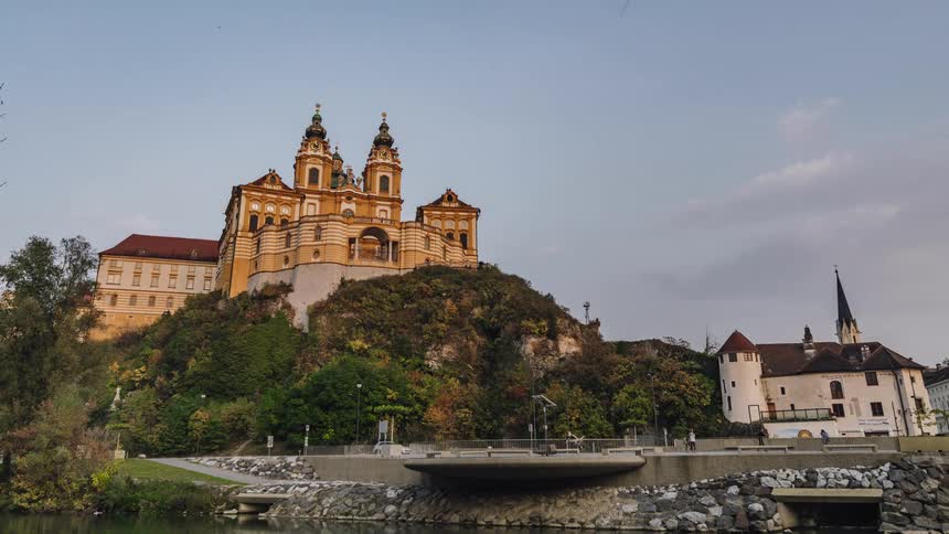 Time lapse of cars driving on a street in front of an european castle over a hill