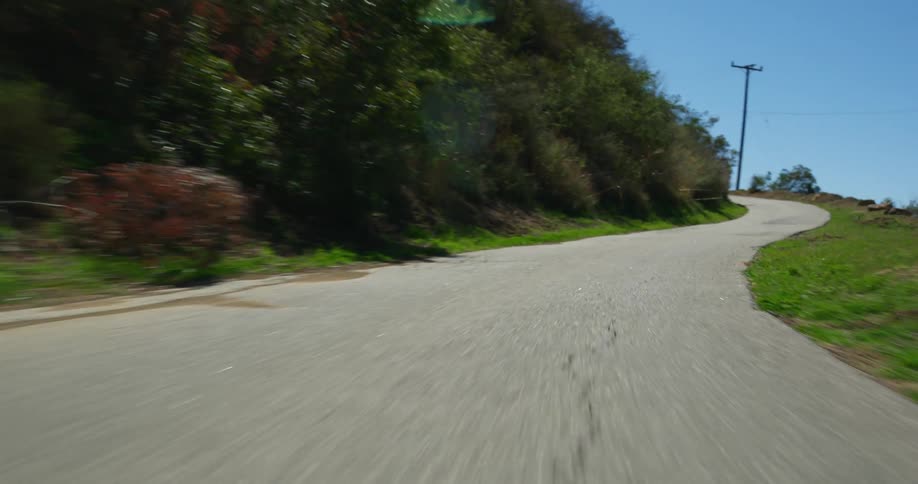 Moving around the bend on a mountain road under a clear blue sky