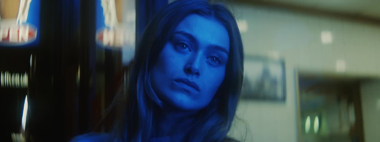 Close up of the face of a beautiful woman staring at the distance under blue lights