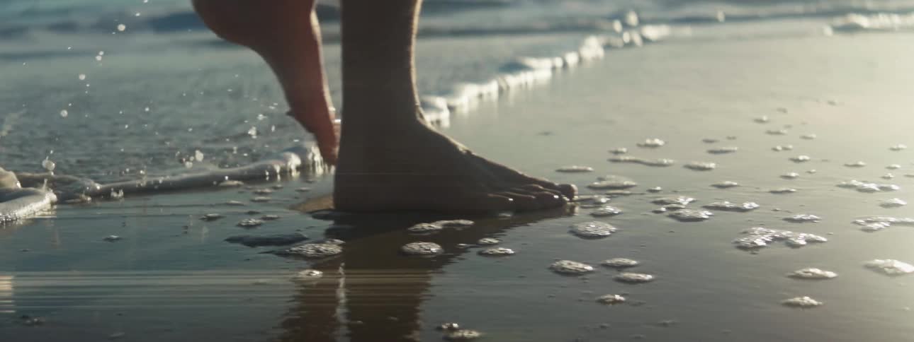 A person is walking out of the ocean