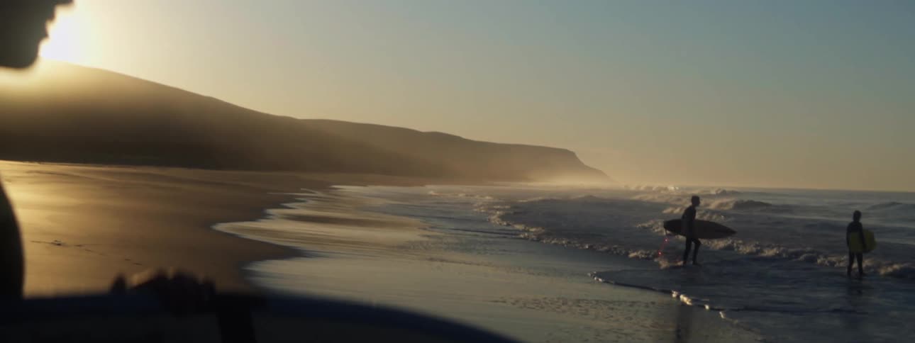 Surfers walk into the ocean