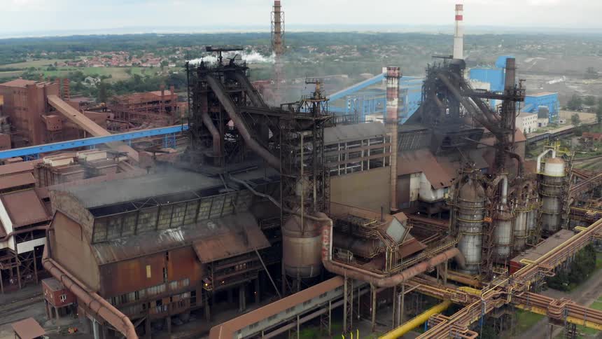Aerial view of smoke rising from a factory polluting the air of a small town