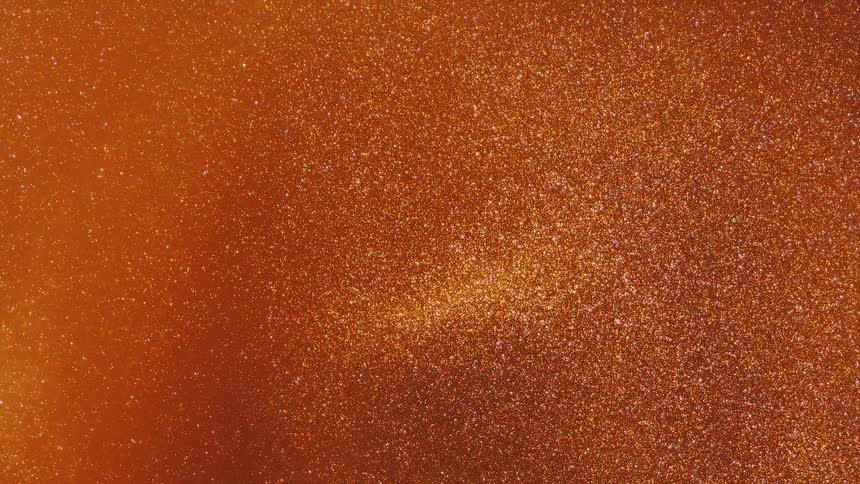 An orange glittery environment expands as it moves and twinkles