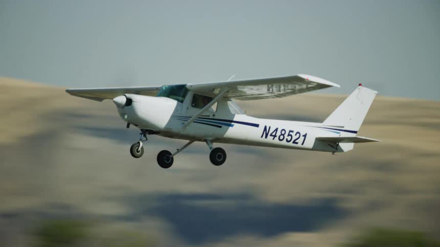 Cessna 150 trainer student single engine airplane takes off from a small airport in the countryside