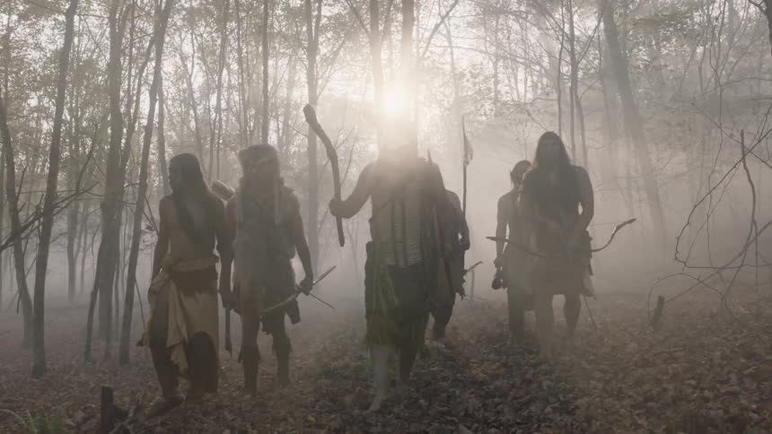 A group of men holding weapons in the forest