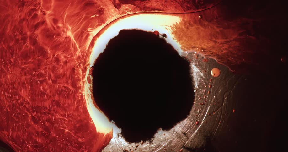 A dark circle is in the middle of vigorously flowing red liquid