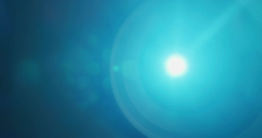 A light is shining through the lens of a projector