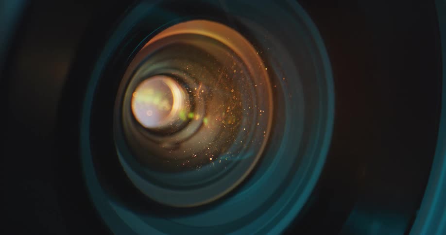 Dust particles are visible in the light shining from the lens of a projector