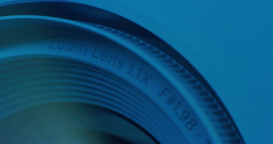 Blue and green light shines on a zoom lens