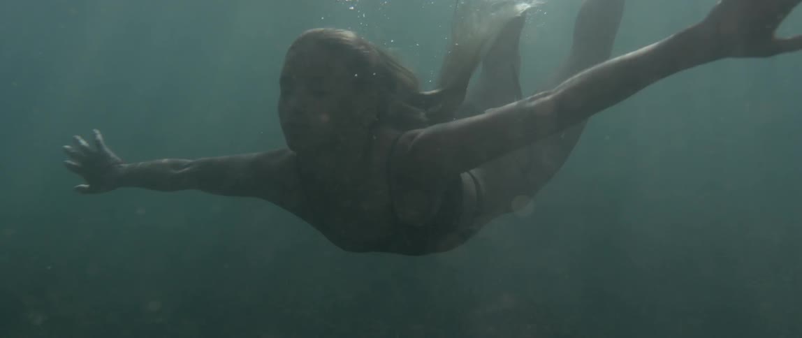A woman is swimming underwater
