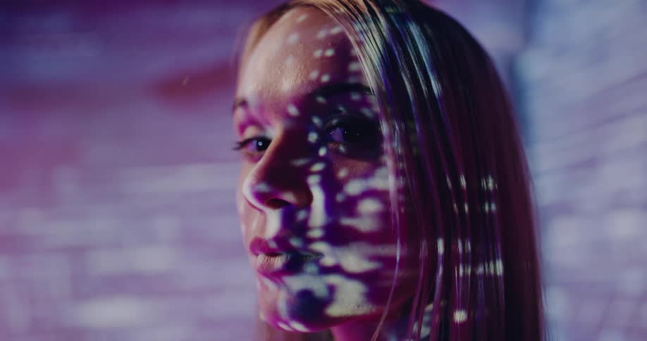 A woman is standing in a room and looks futuristic