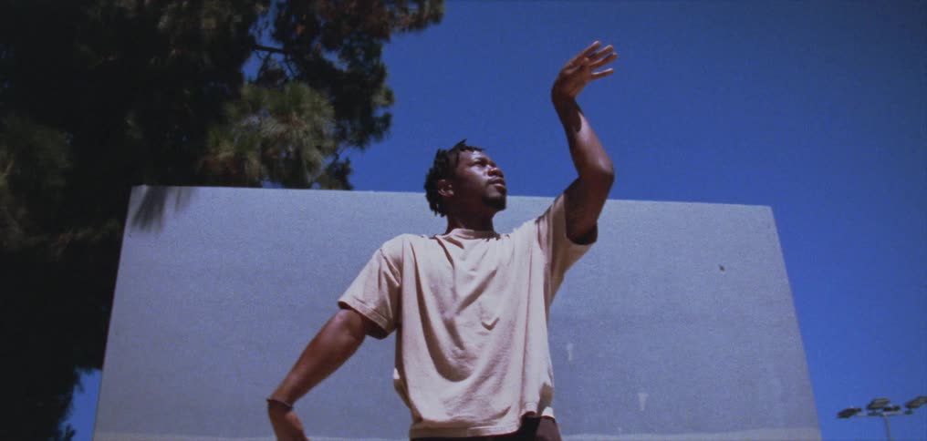 A man is standing outdoors and posing