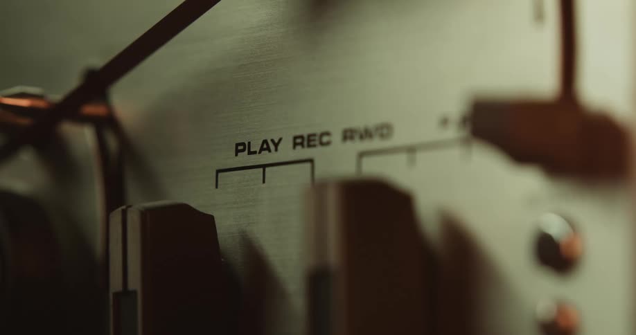 A person turns a dial on a vintage stereo