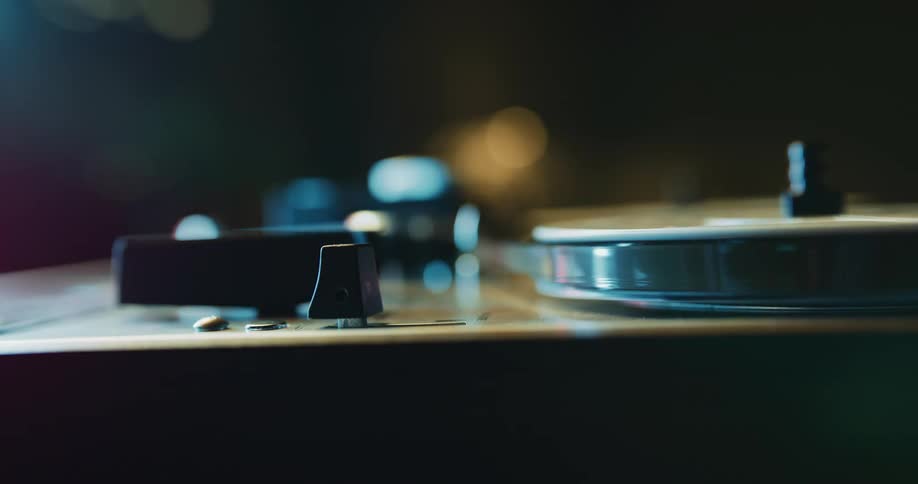A person turning on a reel to reel tape player
