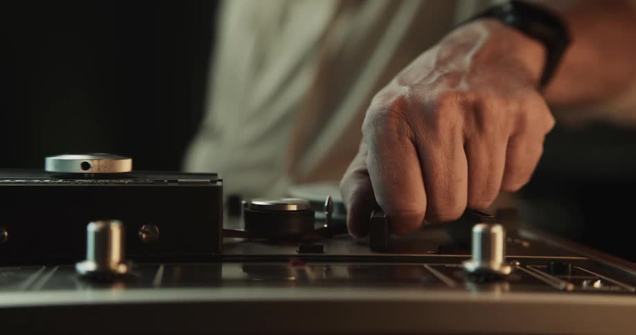 A person using knobs on a recorder