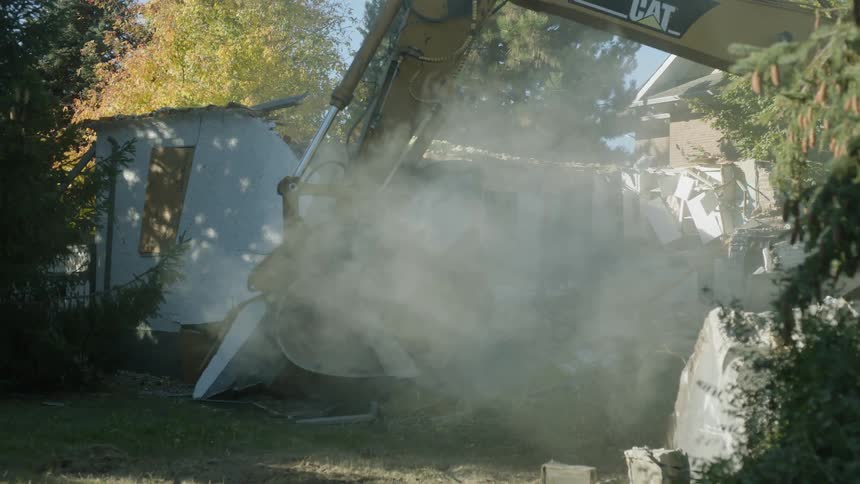 A construction crane demolishes a building