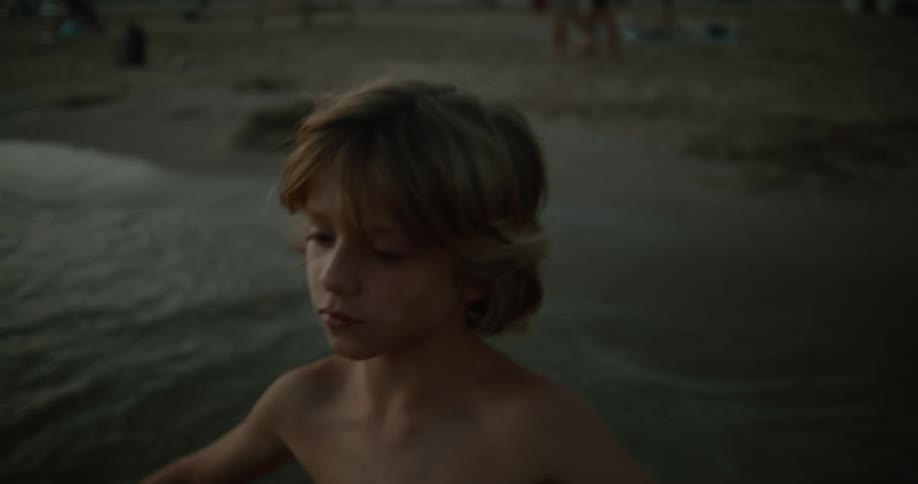 A boy is walking on the beach