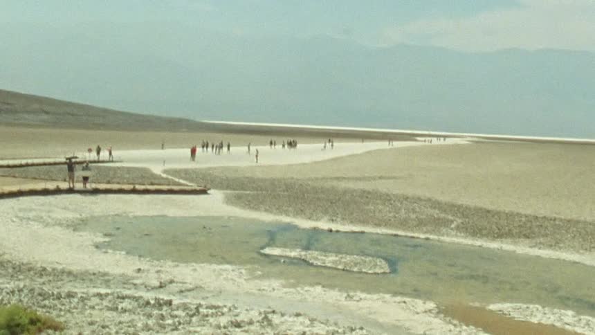Group of tourists visiting a natural attraction in the desert caught on vintage film
