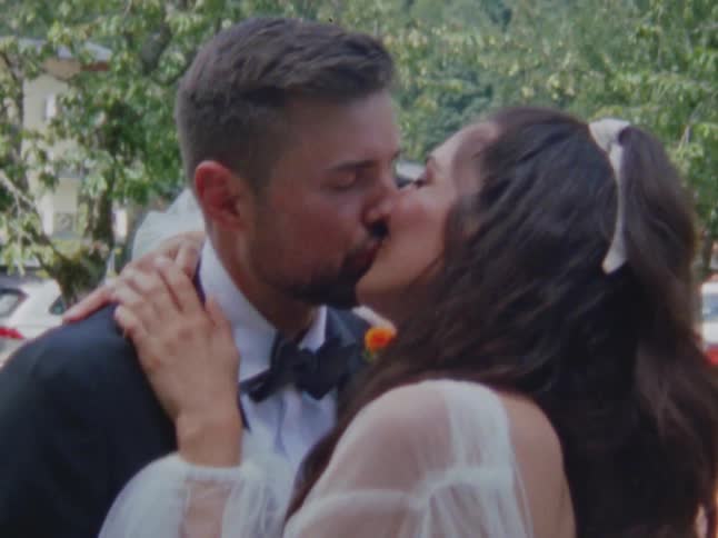 A man and a woman are kissing on their wedding day