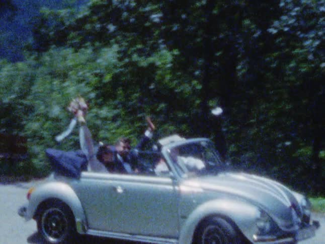 A couple who just got married is driving down the road