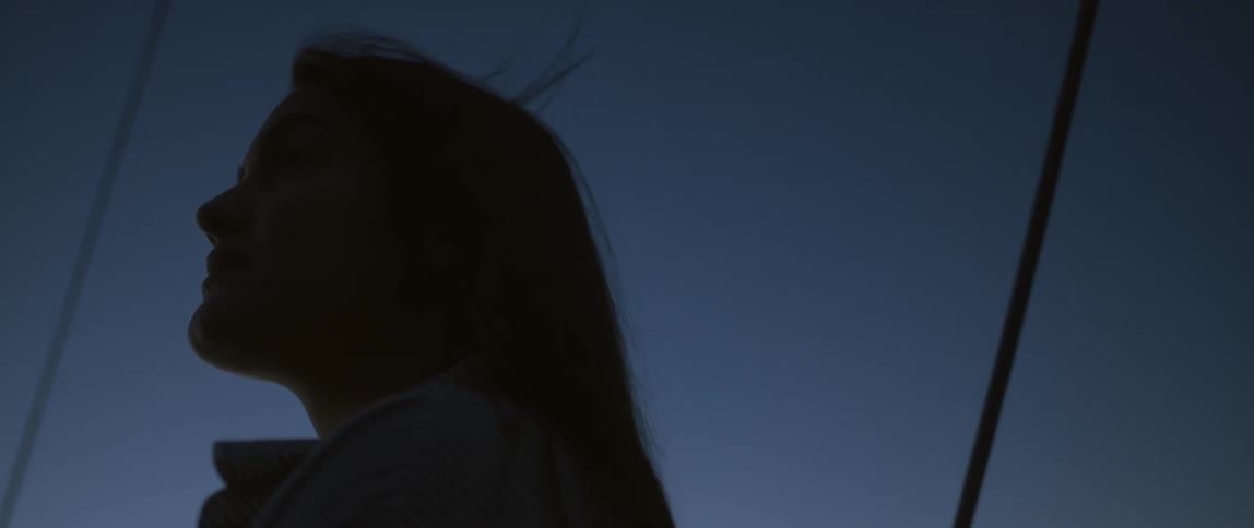 A woman stares forward on a windy day