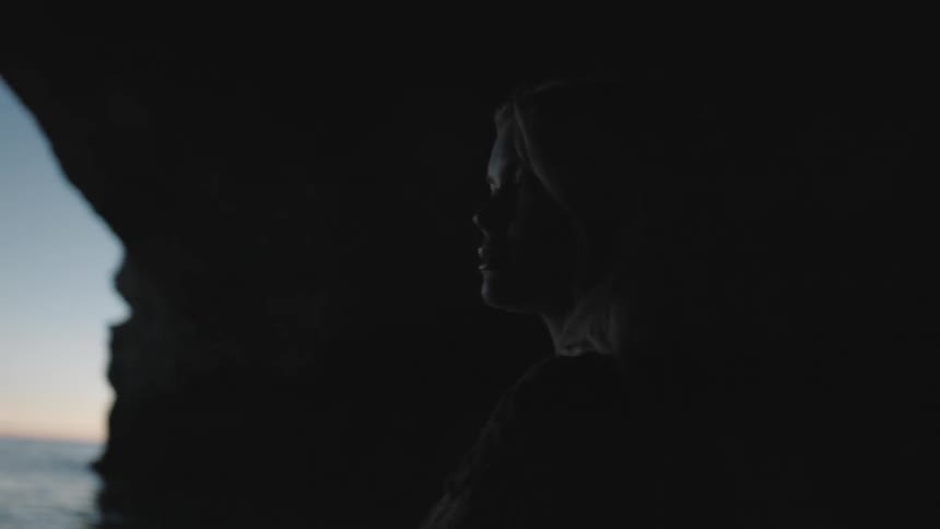 A woman standing in a large ocean cave