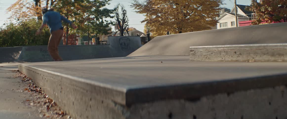 Young man does a nose manual trick on his skateboard in the morning