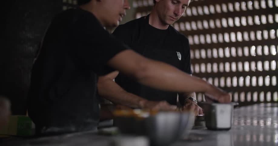 Two male restaurant workers preparing food in the kitchen