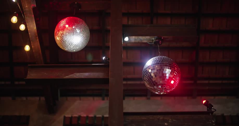 A ceiling with two disco balls spinning slowly