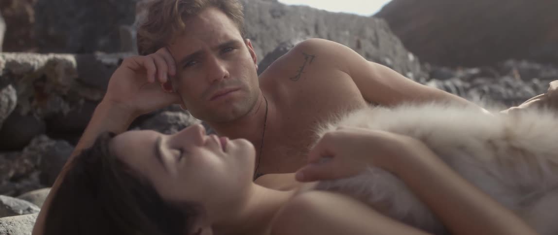 A woman is sleeping as a man lays next to her