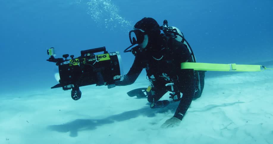A scuba diver underwater with a large camera